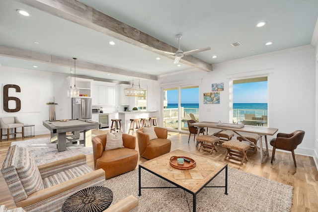 living area featuring light wood-type flooring, beamed ceiling, visible vents, recessed lighting, and baseboards