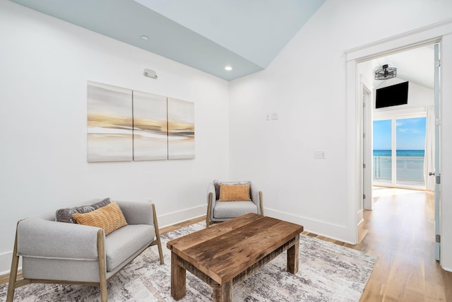 living area featuring vaulted ceiling, light wood-style flooring, recessed lighting, and baseboards