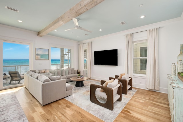 living area with ceiling fan, visible vents, beamed ceiling, and light wood-style flooring