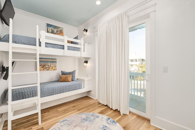 bedroom with recessed lighting, wood finished floors, and access to outside