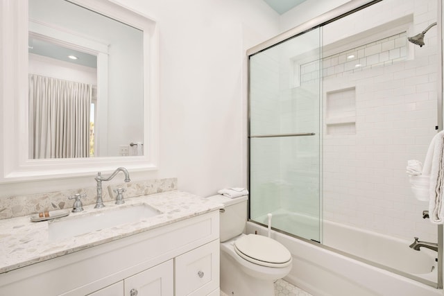 full bathroom with vanity, toilet, and shower / bath combination with glass door
