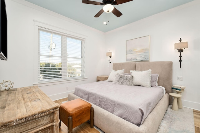 bedroom with ceiling fan, baseboards, and wood finished floors
