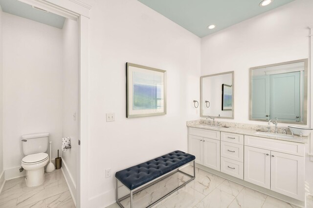 full bathroom with toilet, baseboards, marble finish floor, and a sink