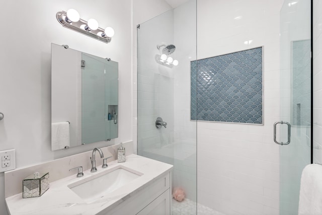 bathroom with a shower stall and vanity