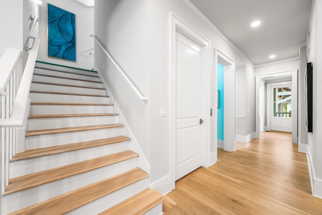 staircase featuring wood finished floors, recessed lighting, and crown molding
