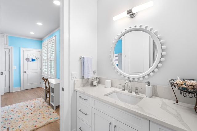 bathroom with recessed lighting, wood finished floors, and vanity