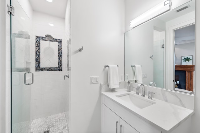 bathroom with a shower stall, visible vents, and vanity
