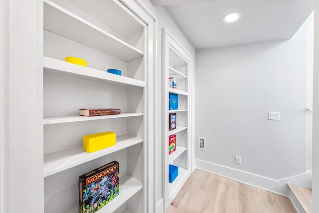 interior space featuring baseboards, visible vents, wood finished floors, and recessed lighting