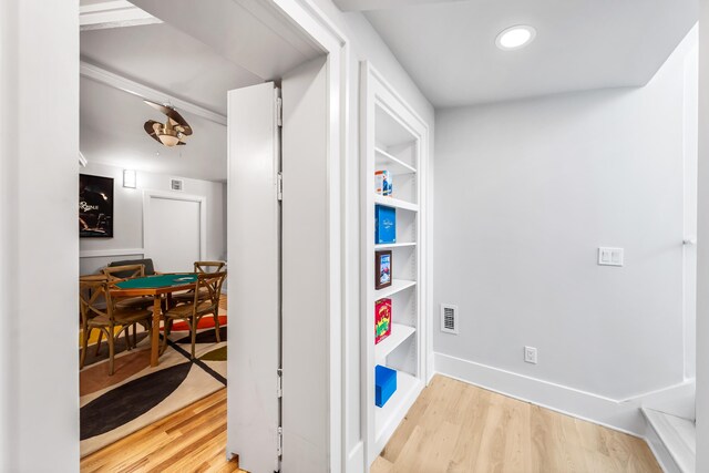corridor featuring visible vents, baseboards, and wood finished floors