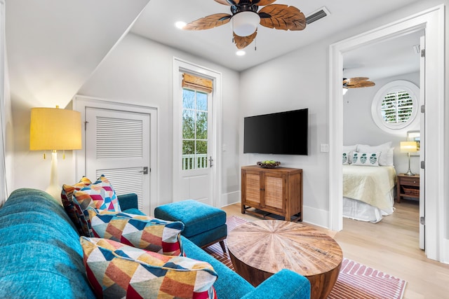 living room with a wealth of natural light, light wood-style floors, recessed lighting, and a ceiling fan