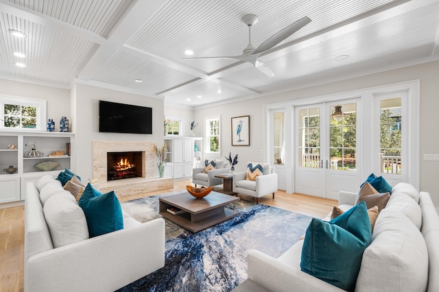 living room featuring coffered ceiling, light wood-style flooring, recessed lighting, a high end fireplace, and a ceiling fan