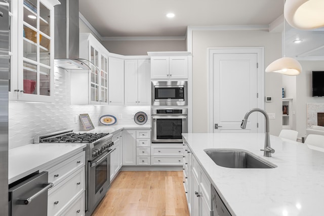 kitchen featuring crown molding, a sink, light wood finished floors, white cabinetry, and appliances with stainless steel finishes