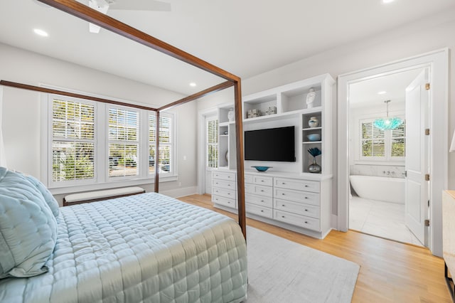 bedroom featuring light wood-style floors, ensuite bath, multiple windows, and recessed lighting