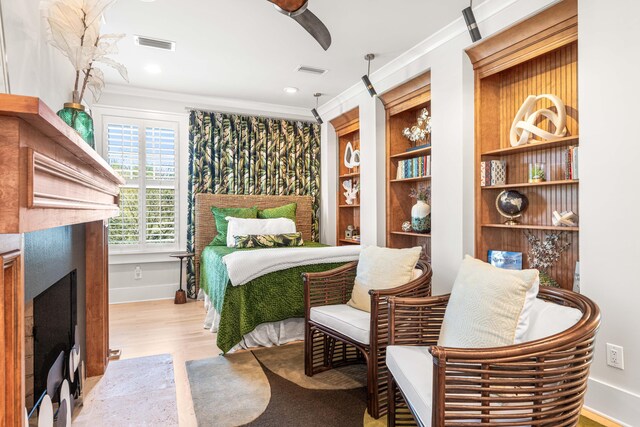 bedroom with a fireplace with flush hearth, visible vents, and crown molding