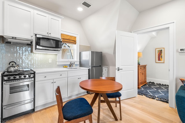 kitchen with visible vents, under cabinet range hood, light wood-type flooring, and stainless steel appliances