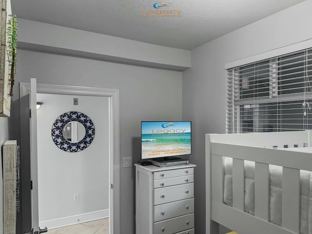 bedroom with light tile patterned flooring and baseboards