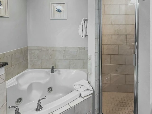full bath featuring a shower stall and a jetted tub