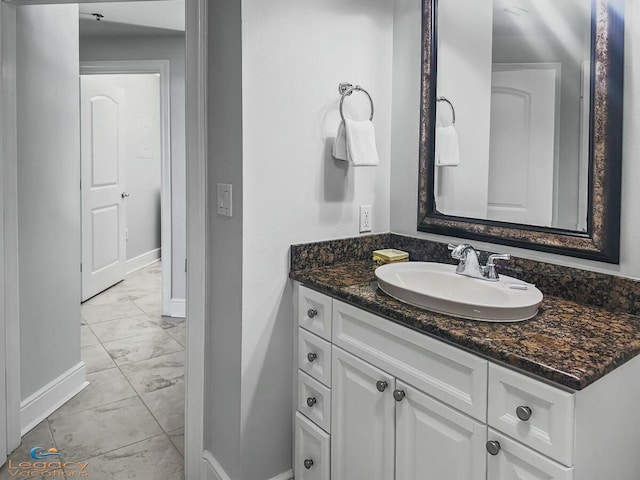bathroom with vanity, baseboards, and marble finish floor