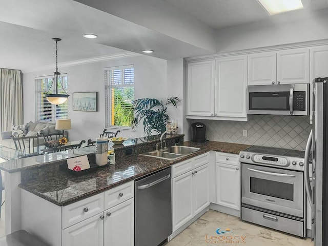 kitchen featuring a sink, stainless steel appliances, a peninsula, and white cabinetry