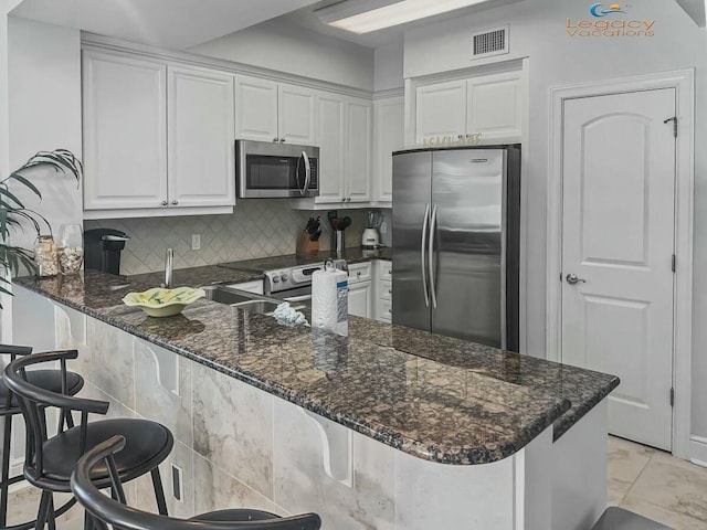 kitchen with white cabinetry, a peninsula, and stainless steel appliances