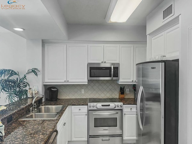 kitchen with a sink, stainless steel appliances, visible vents, and white cabinetry