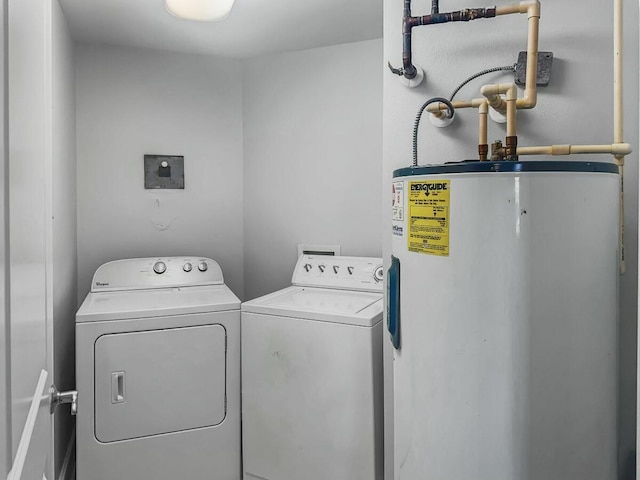clothes washing area featuring washer and clothes dryer, laundry area, and electric water heater