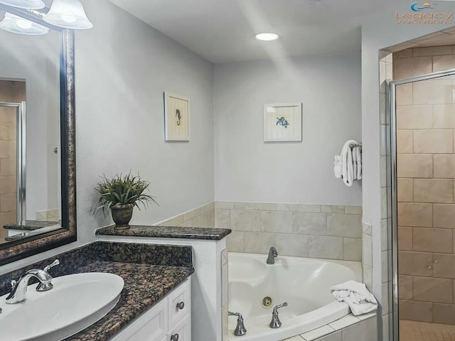 full bath featuring vanity, a stall shower, and a whirlpool tub