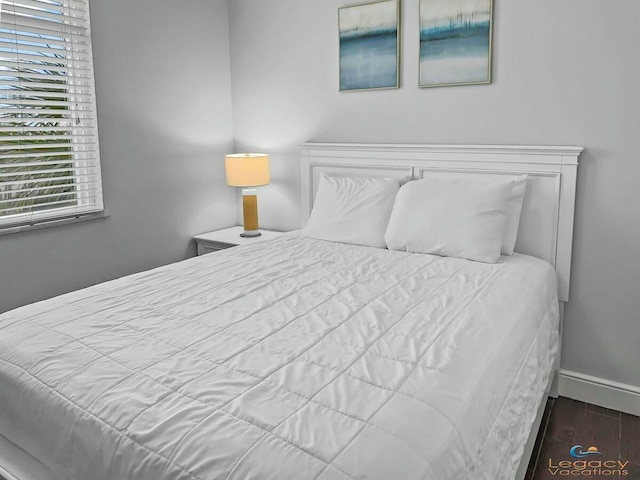 bedroom with baseboards and wood finished floors