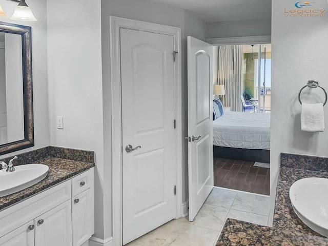bathroom with marble finish floor, vanity, and ensuite bathroom