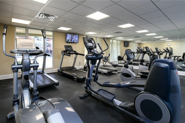 exercise room featuring a paneled ceiling, visible vents, and baseboards
