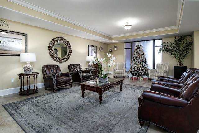 living room featuring a tray ceiling, baseboards, and ornamental molding