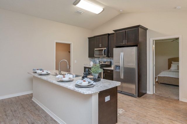 3362 Peeble Dr, Crestview, FL 32539 - kitchen featuring appliances with stainless steel finishes, a sink, dark brown cabinets, light wood-style flooring, and lofted ceiling
