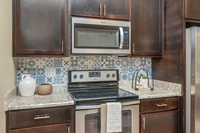 3362 Peeble Dr, Crestview, FL 32539 - kitchen with stainless steel appliances, dark brown cabinets, decorative backsplash, and light stone counters