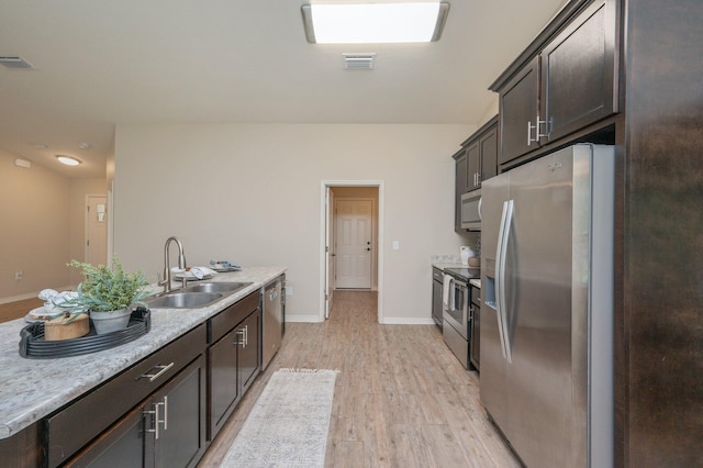 3362 Peeble Dr, Crestview, FL 32539 - kitchen with stainless steel appliances, a sink, dark brown cabinetry, light wood-style floors, and baseboards