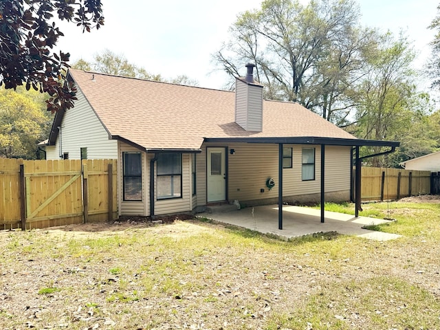 rear view of house with a patio, fence, a chimney, and a shingled roof