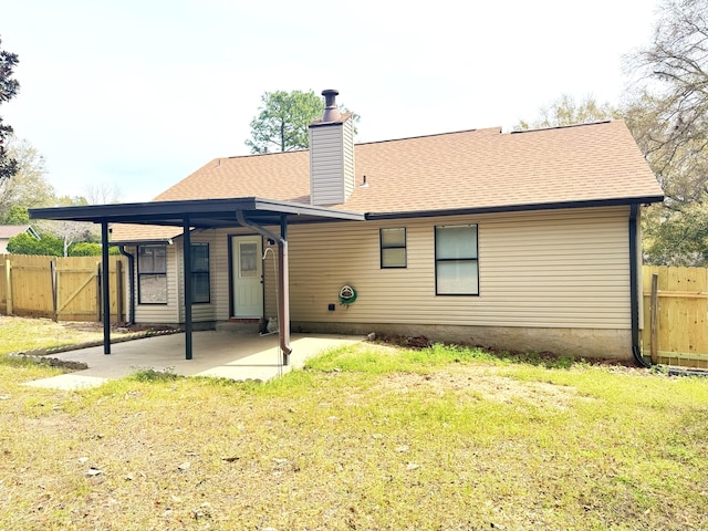 rear view of property featuring a patio, fence, a yard, and a chimney