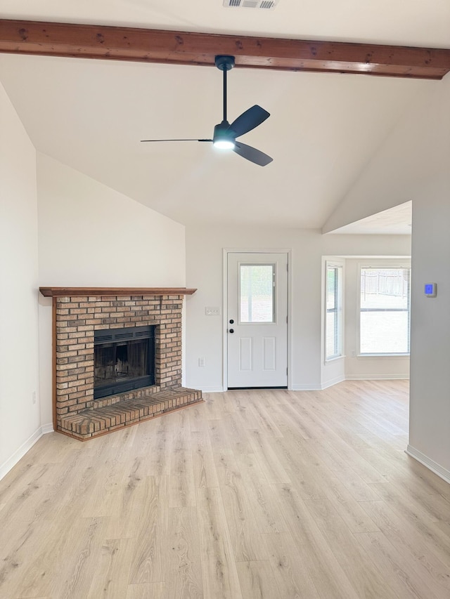 unfurnished living room featuring ceiling fan, wood finished floors, a fireplace, and beamed ceiling
