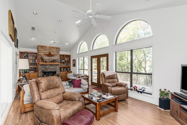 446 Marion Dr, Niceville, FL 32578 - living area with a fireplace, light wood-style floors, high vaulted ceiling, a ceiling fan, and visible vents