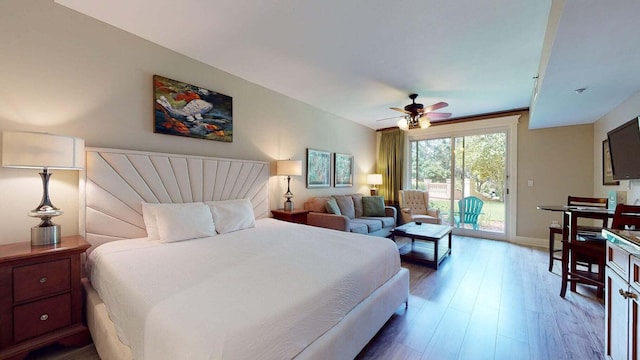 bedroom featuring access to exterior, baseboards, a ceiling fan, and wood finished floors