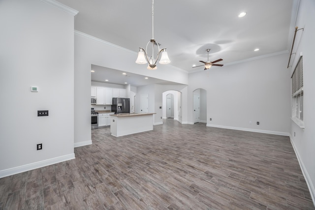 367 Brighton Cv, Freeport, FL 32439 - unfurnished living room featuring ceiling fan with notable chandelier, wood finished floors, arched walkways, and ornamental molding