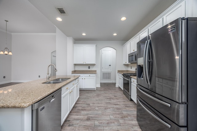 367 Brighton Cv, Freeport, FL 32439 - kitchen with stainless steel appliances, a sink, arched walkways, an island with sink, and white cabinets