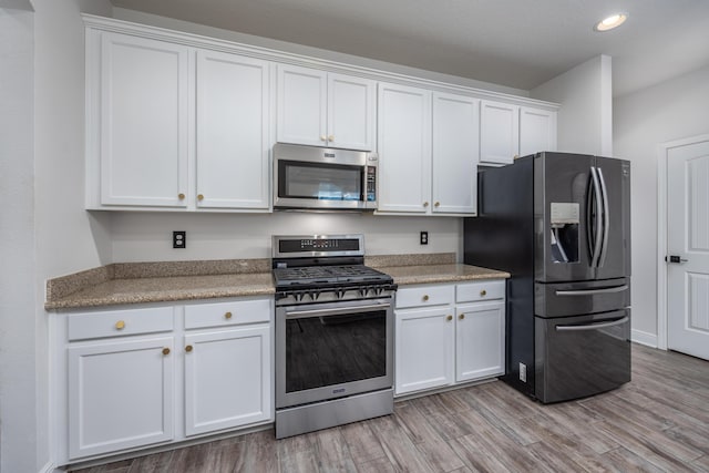 367 Brighton Cv, Freeport, FL 32439 - kitchen with white cabinets, light wood-style flooring, light countertops, stainless steel appliances, and recessed lighting