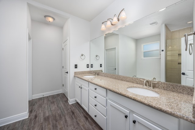 367 Brighton Cv, Freeport, FL 32439 - bathroom featuring double vanity, wood finished floors, baseboards, and a sink