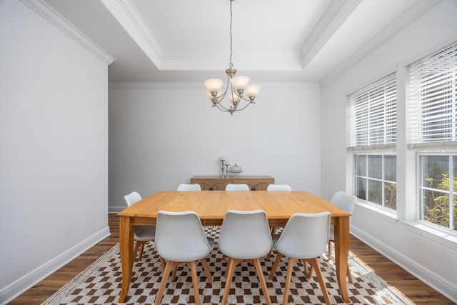 dining room featuring an inviting chandelier, dark wood-type flooring, and a raised ceiling