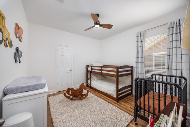 bedroom with baseboards, ceiling fan, and wood finished floors