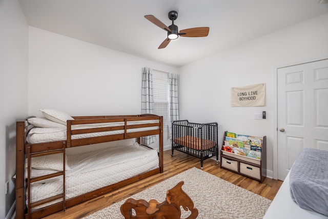 bedroom with baseboards, wood finished floors, and a ceiling fan