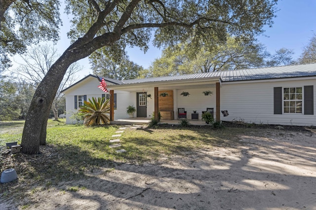 ranch-style home featuring metal roof and covered porch