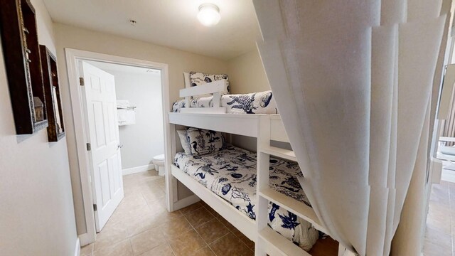 16819 Front Beach Rd Unit 210, Panama City Beach, FL 32413 - bedroom featuring tile patterned floors, baseboards, and connected bathroom