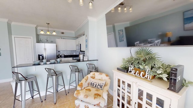 16819 Front Beach Rd Unit 210, Panama City Beach, FL 32413 - kitchen featuring appliances with stainless steel finishes, crown molding, a peninsula, tasteful backsplash, and light tile patterned floors