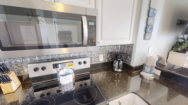 16819 Front Beach Rd Unit 210, Panama City Beach, FL 32413 - kitchen featuring appliances with stainless steel finishes, decorative backsplash, white cabinetry, and dark stone countertops